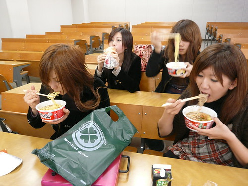 Japan: Girls eating noodles in lecture theatre
