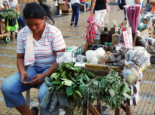 herbal medicine street sidewalk vendor woman texting, cellphone  Buhay Pinoy Philippines Filipino Pilipino  people pictures photos life Philippinen  菲律宾  菲律賓  필리핀(공화국)     