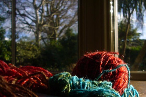 Kirsty Hall, photograph of balls of brightly coloured yarn in front of a blurred winter landscape