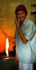 Oil is lit, cook at the Toast Bakery on his cell, Boudha, Kathmandu, Nepal