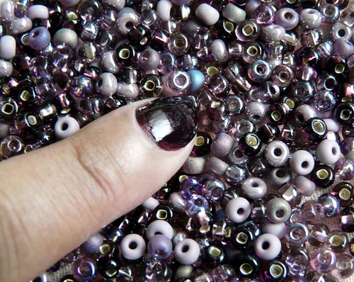 Purple beads with manicured nail