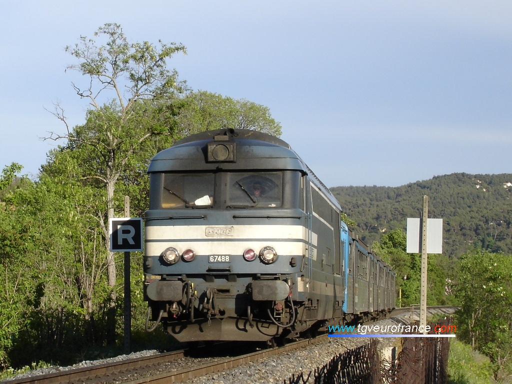 Une locomotive thermique BB 67400 en livrée Arzens approche de la gare d'Aix-en-Provence avec sa rame réversible régionale
