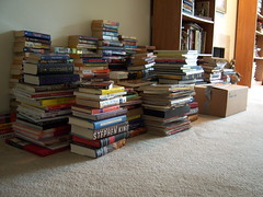 A pile of books on the floor of a living room