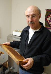 Allen Garr with a frame of waxen honeycombs used inside his bee boxes.