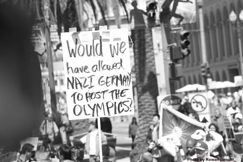 Protester with sign:  Would we have allowed Nazi Germany to host the Olympics?