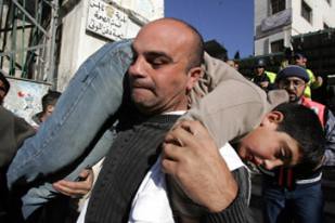 Gaza resident carries wounded youth on his back as the Israeli Defense Forces launched a series of attacks during January of 2008. by Pan-African News Wire File Photos.