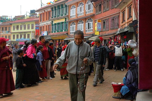 For man of peace disagreement of no interest, porters and customers engage in loud angry argument while the local folks look on at the Boudha Stupa. One Tibetan man praying his mala walks quietly and quickly away, Nepal by Wonderlane