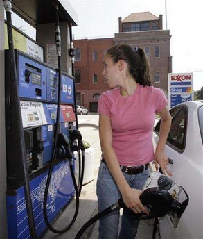 A woman fills up her vehicle with gasoline