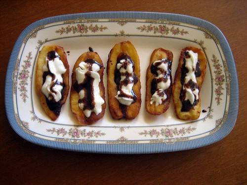 Fried banana slices with whipped cream and chocolate syrup