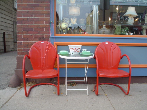 two red chairs in front of antique store