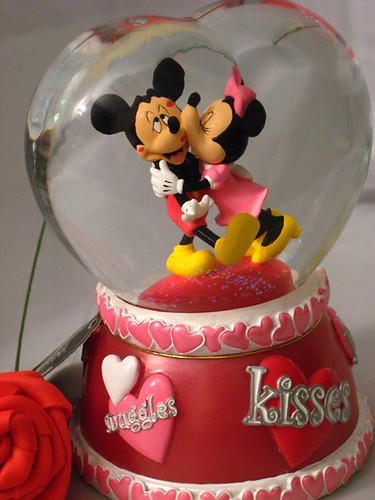 Mickey getting lots of kisses from Minnie in heart shaped globe