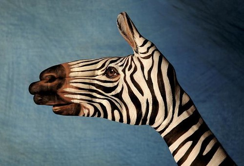 painting of a zebra on the artist's hand