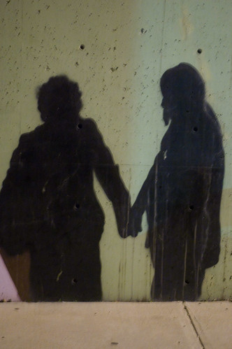 graffiti shadows of two people holding hands