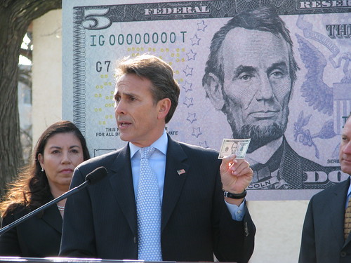 Michael Lambert, Assistant Director, Division of Reserve Bank Operations and Payment Systems, Federal Reserve Board, points out features of the new $5 bill. Anna Escobedo Cabral, Treasurer of the United States stands to the left.