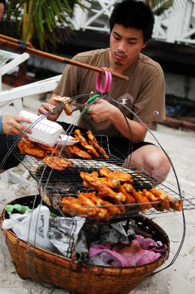 At lending a hand at grilling chicken, Ko Samet