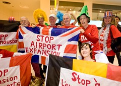 Local MP John McDonnell joins anti-aviation campaigners with the flags of the other protesting nations at Heathrow Terminal One to demonstrate against the 3rd runway and aviation expansion. by Euroflashmob Heathrow and Europe