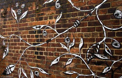 graffiti of vines, painted in white on red brick