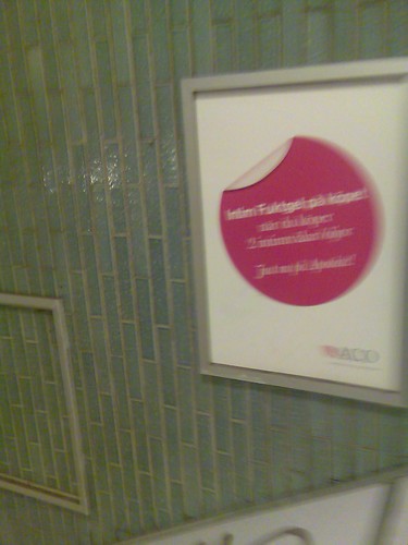 Annonstavla i en tunnelbanenedgång med en lila cirkel i mitten med vit flik överst till vänster och med texten 'Intim Fuktgel på köpet när du köper 2 intimtvålar/oljor Just nu på Apoteket!'