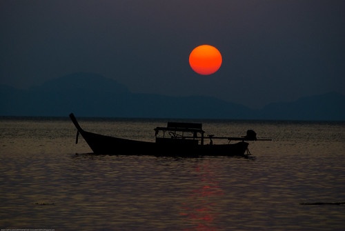 Longtail boat at sunset at Ting Rai Bay, Koh Jum, Thailand by Adam Cathro.