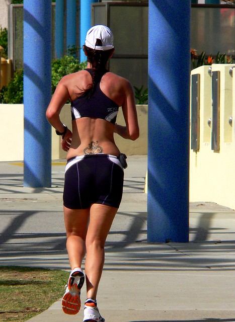 Tattoo running. a jogger along the beach side path at Redcliffe.