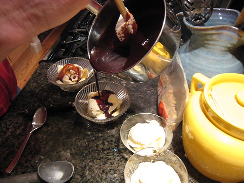 Pouring hot fudge sauce on the ice cream dessert