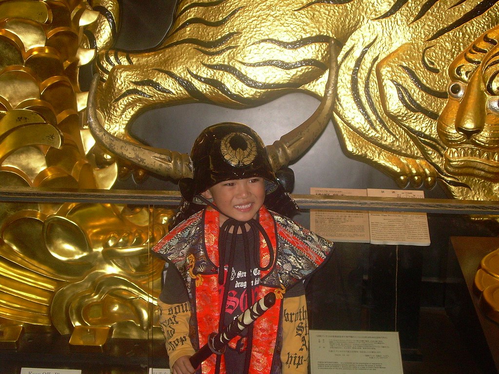 El niño feliz vestido de samurai en el Castillo de Osaka-jo