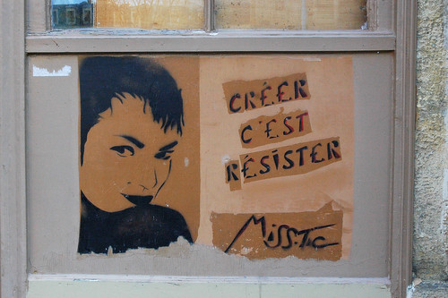 stencil graffiti: image of a woman's face, with the words "creer c'est resister"