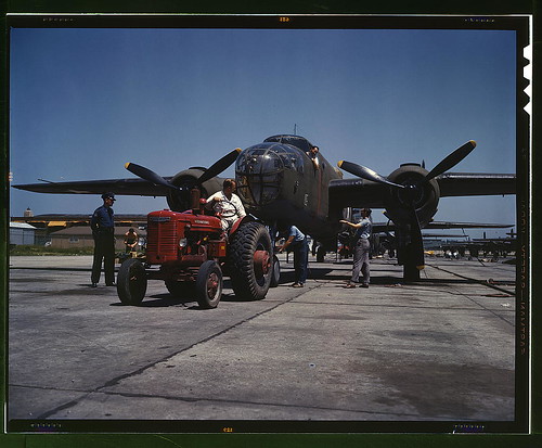 Warbird picture - B-25 bomber planes at the North American Aviation, Incorporated being hauled along an outdoor assembly line with an &quot;International&quot; tractor, Kansas City, Kansas
