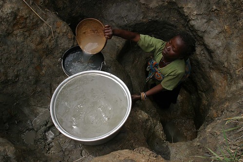 Woman with child collecting water by hdptcar on Flickr