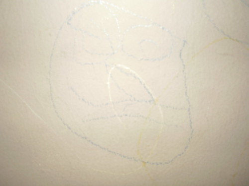 Crayon on wall....very nice face by a 3 year old Elyse