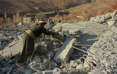 A villager looks through a rubble at the Qlatooka village near Iraq's border with Turkey on Sunday Dec 16 2007