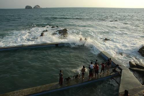 Wave washes over a Pacific Ocean pool with kids and adults, South Mazatlan, Sinaloa, Mexico by Wonderlane