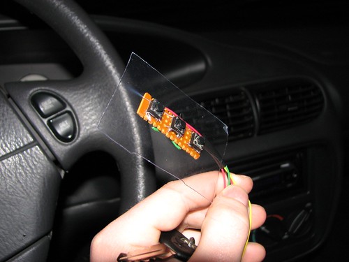 Three momentary touch switches mounted on a small breadboard, which will fit under one side of the steering wheel.  The unit has a sheet of plastic mounted on it so that wire ties can be used to hold it to the back of the steering wheel.