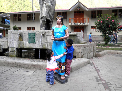 niños juegan alrededor de estatua