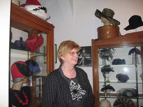 Picture of Tiny Meihuizen-Wijker, owner of the museum, in front of the hats she has made herself