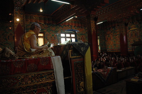 His Holiness Jigdal Dagchen Sakya, on his throne, wearing traditional style silk garments, white and yellow katag, Tharlam Monastery, Boudha, Kathmandu, Nepal with monks and sangha, traditional wall murals of Lord Buddha's lifestory by Wonderlane