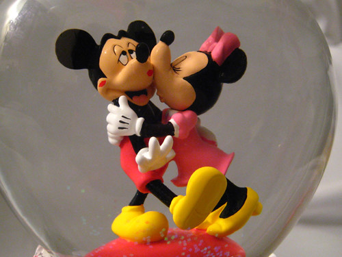 Mickey getting lots of kisses from Minnie in heart shaped globe