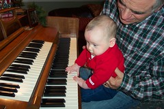 Talia practices the piano with Grandpa