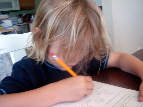 k doing schoolwork, hair in his face