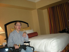 Darrell in his wheelchair, sitting beside the bed