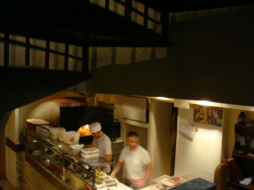 Cocineros en acción con el horno de leña al fondo