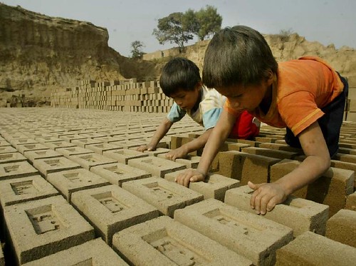 children working stacking bricks
