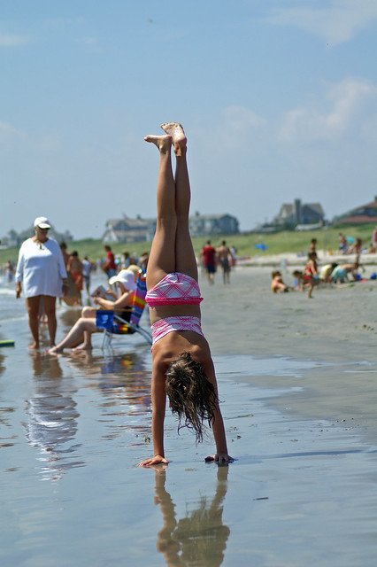 Young woman in bikini performing handstand