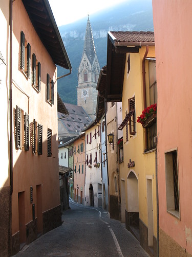 Alte Gasse im historischen Dorfkern mit Blick auf die Traminer Kirche im Hintergrund