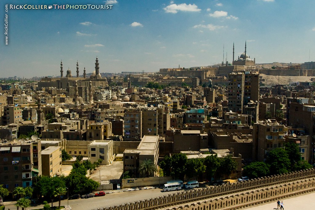 The Cairo city skyline as seen from the top of the spiral minaret at Ibn Tulun mosque, featuring the mosque of Sultan Hassan on the left and Citadel of Saladin on right