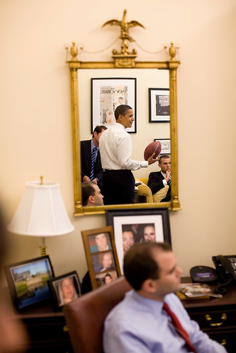 President Barack Obama is reflected in a mirror during an impromptu drop-by visit with speechwriters in David Axelrod's office in the West Wing of the White House on May 21, 2009.