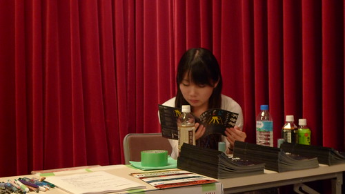 Tsunaoka reading the brochure