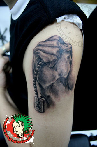 Fist Holding Dog Tags Tattoo by Shanghai Tattoo