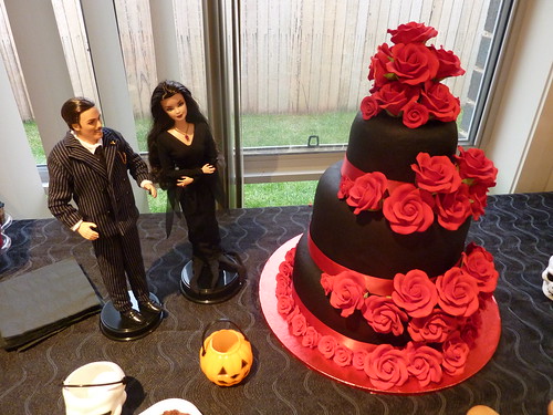The chocolate three tiered wedding cake above with red roses is 