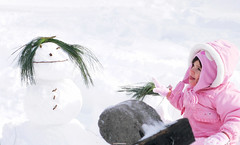 Snowman and little girl in central park